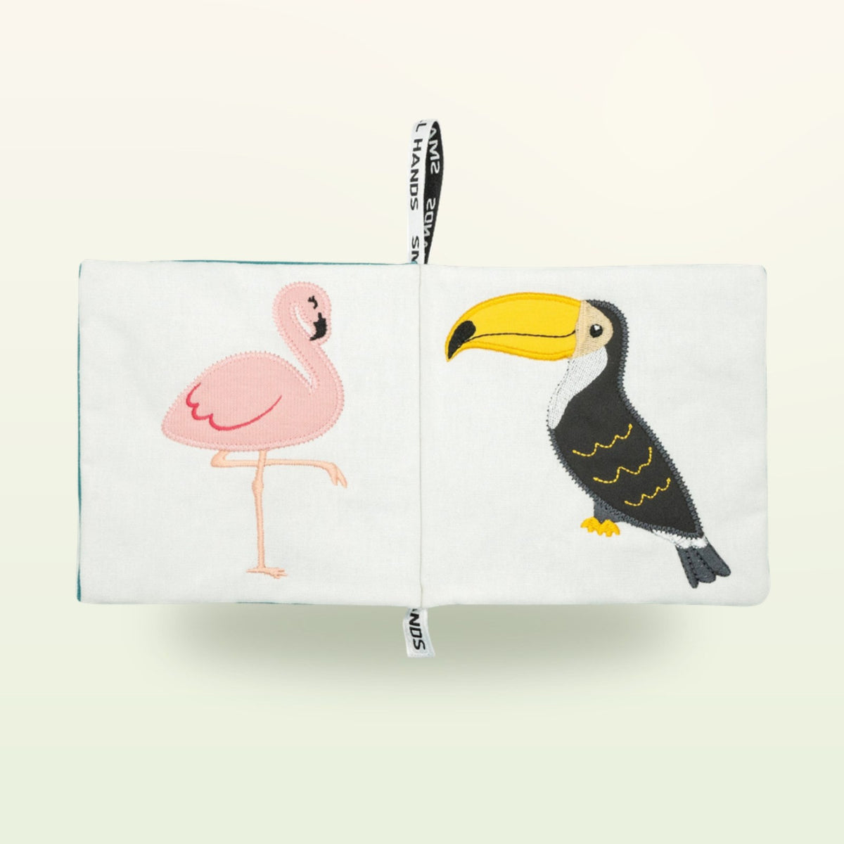 Small Hands Birds Montessori cloth book open – pink flamingo and toucan on a soft cream background – from 0 months