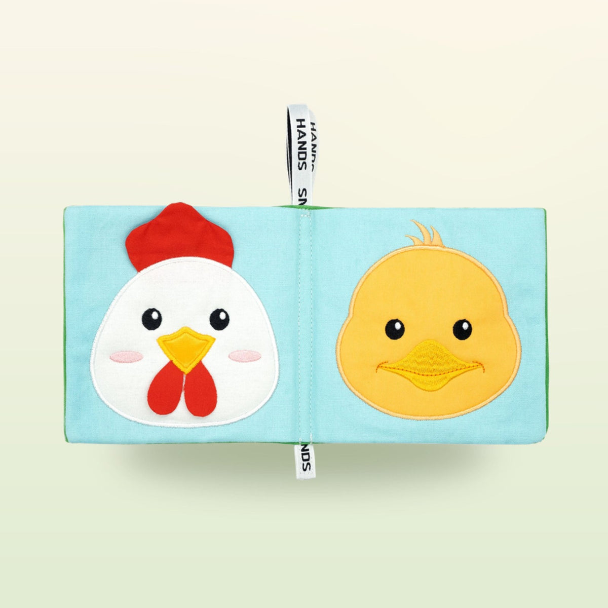 My First Book Small Hands Bauernhof Stoffbuch Doppelseite mit Huhn und Küken auf sanftem Wiesengrün-Hintergrund – ab 0 Monaten