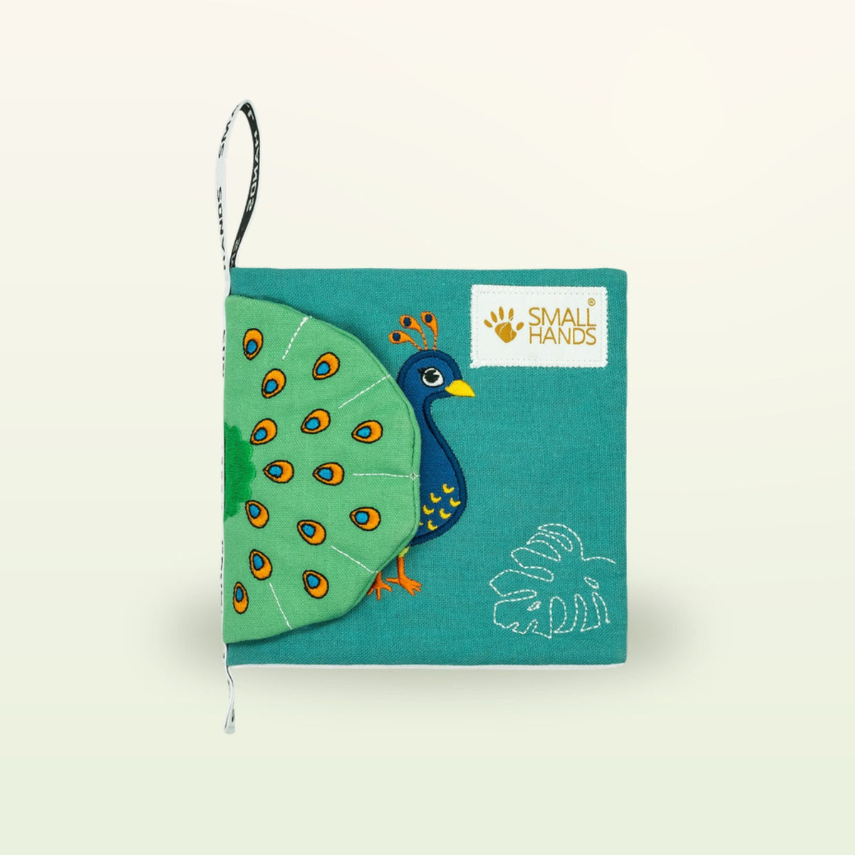 Small Hands Birds Montessori cloth book – closed cover with embroidered peacock and monstera leaf on a soft cream background – from 0 months