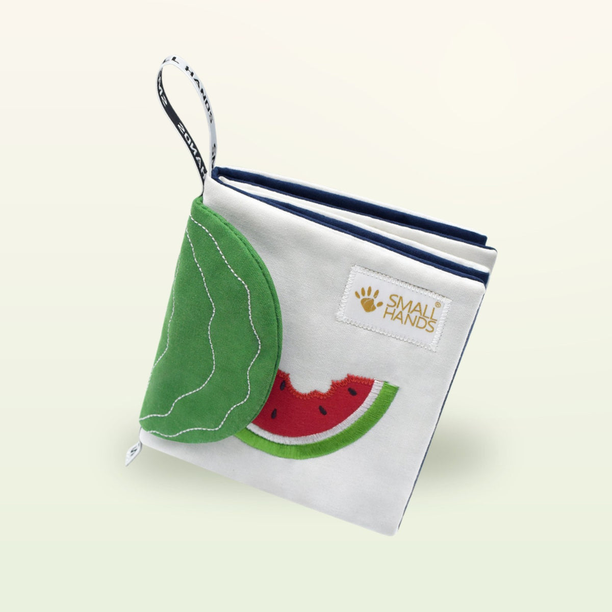 Small Hands Exotische Früchte Montessori Stoffbuch von oben mit Wassermelone und Blatt-Flap auf sanftem Creme-Hintergrund – ab 0 Monaten