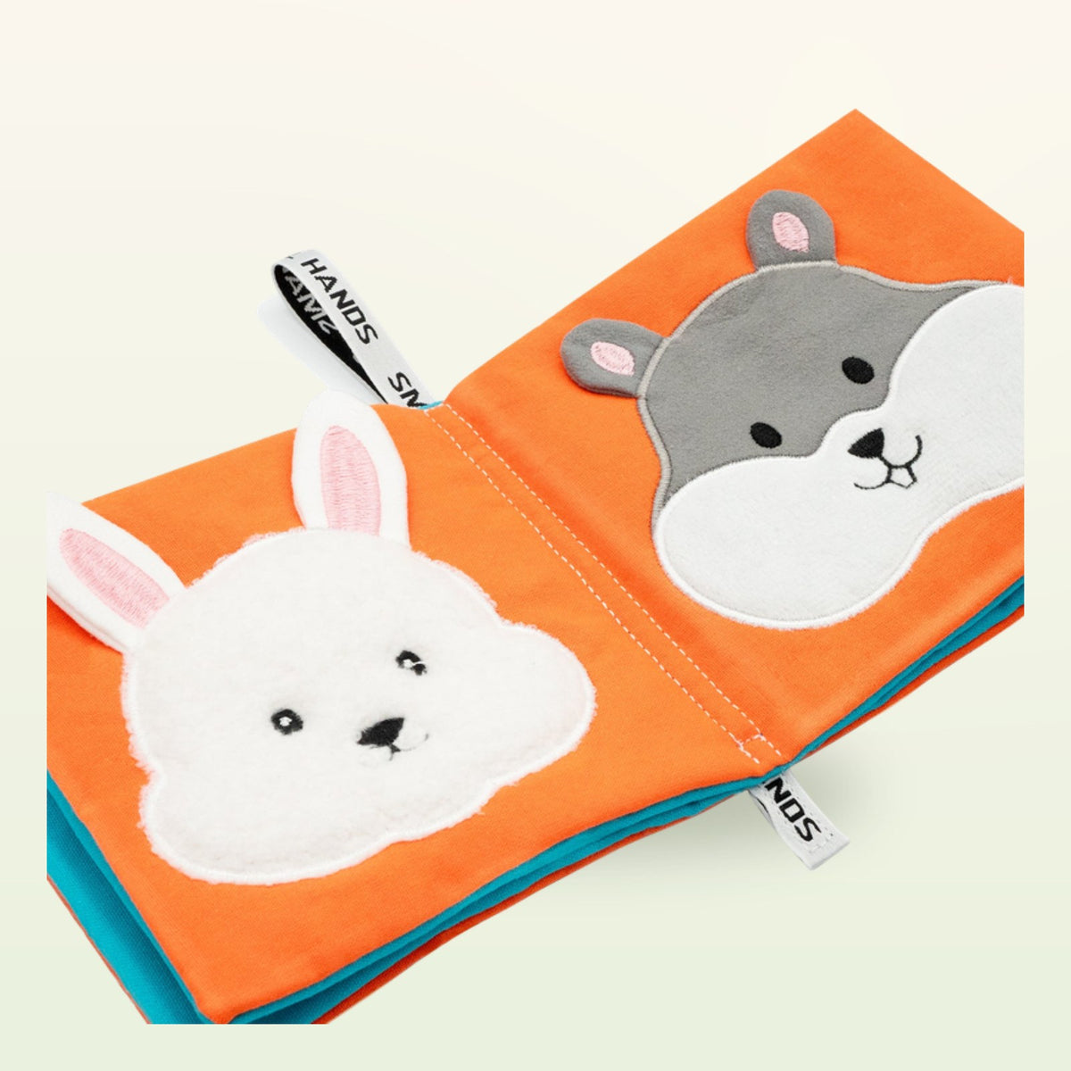 Small Hands Mascotas libro de tela Montessori – primer plano con conejo blanco y hámster gris sobre fondo suave de color crema – a partir de 0 meses