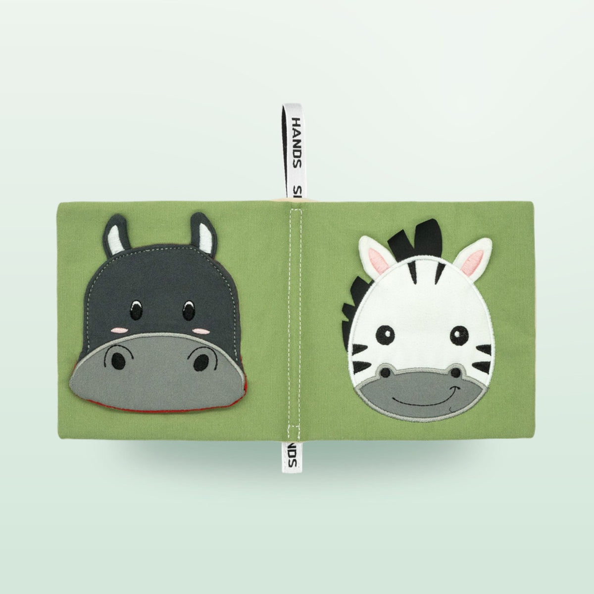Small Hands Tiere Afrikas Montessori Stoffbuch Doppelseite mit Nilpferd und Zebra auf sanftem Waldgrün-Hintergrund – ab 0 Monaten