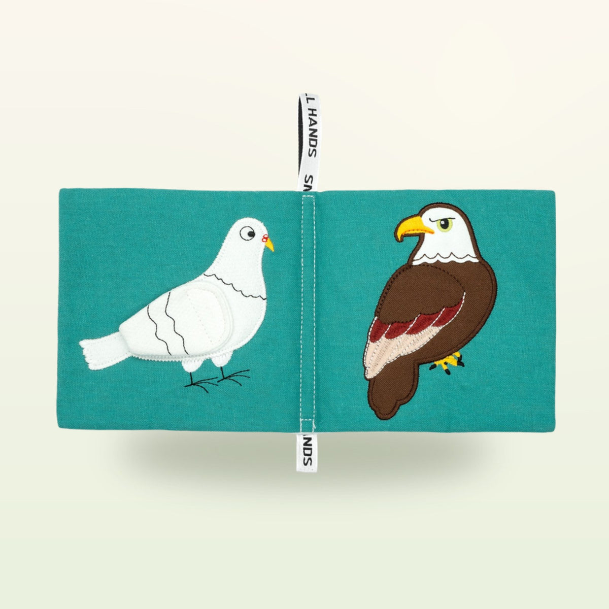 Small Hands Birds Montessori cloth book open – white dove and bald eagle on a soft cream background – from 0 months