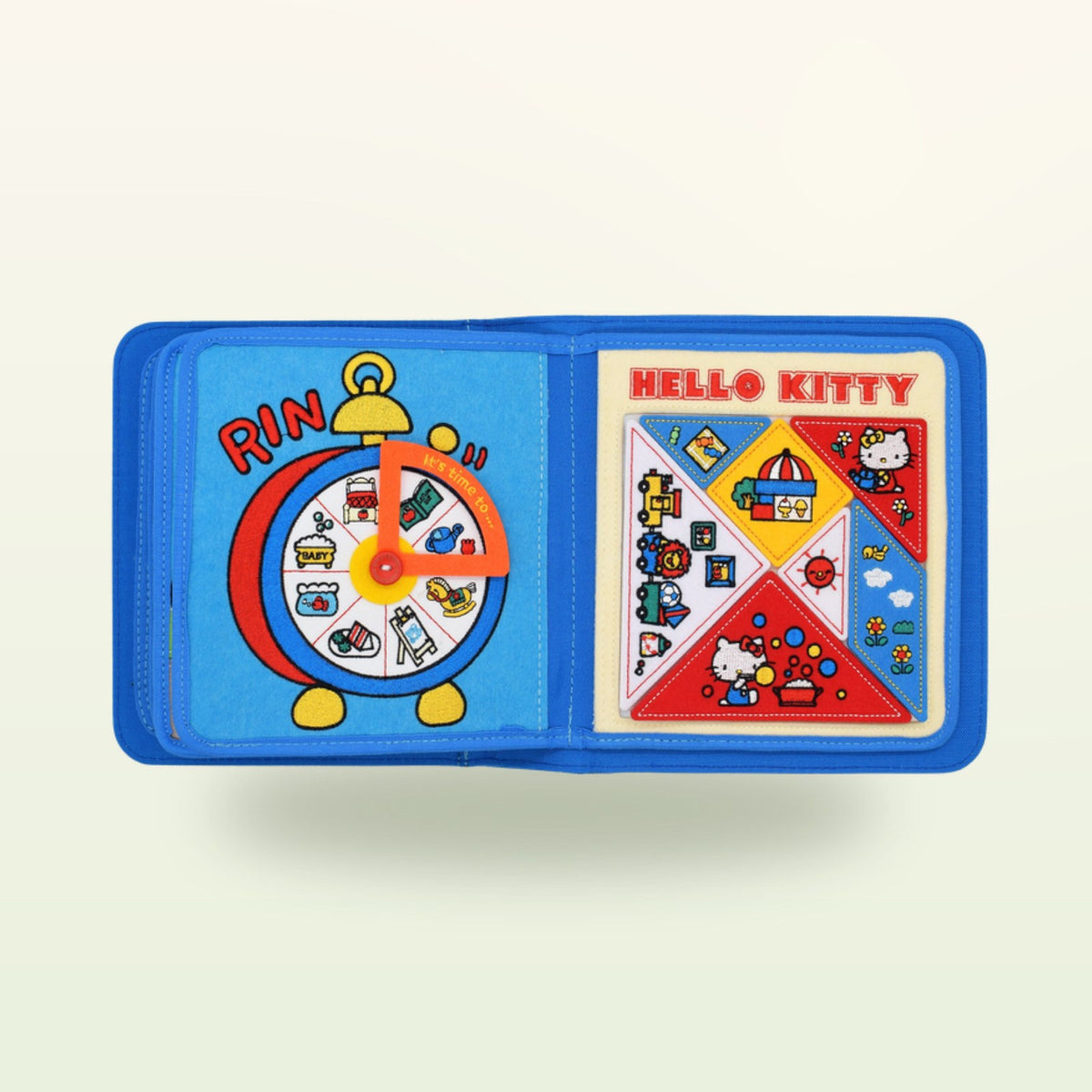 Doble página con reloj de fieltro y puzle del quiet book Hello Kitty sobre fondo suave de color crema – a partir de 1 año