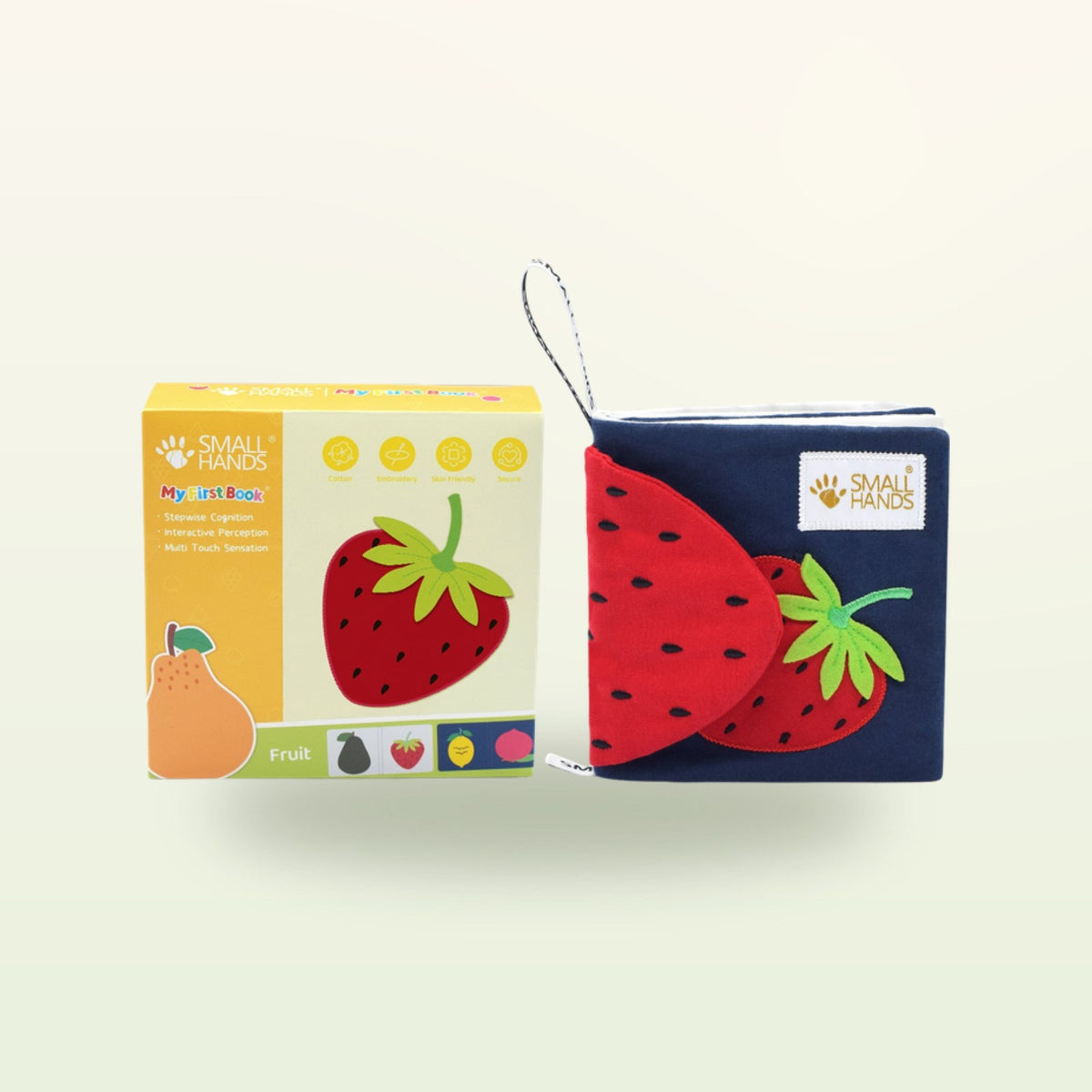 Small Hands Bunte Früchte Montessori Fühlbuch – Verpackung mit Buch und roter Erdbeere auf sanftem Creme-Hintergrund – ab 0 Monaten