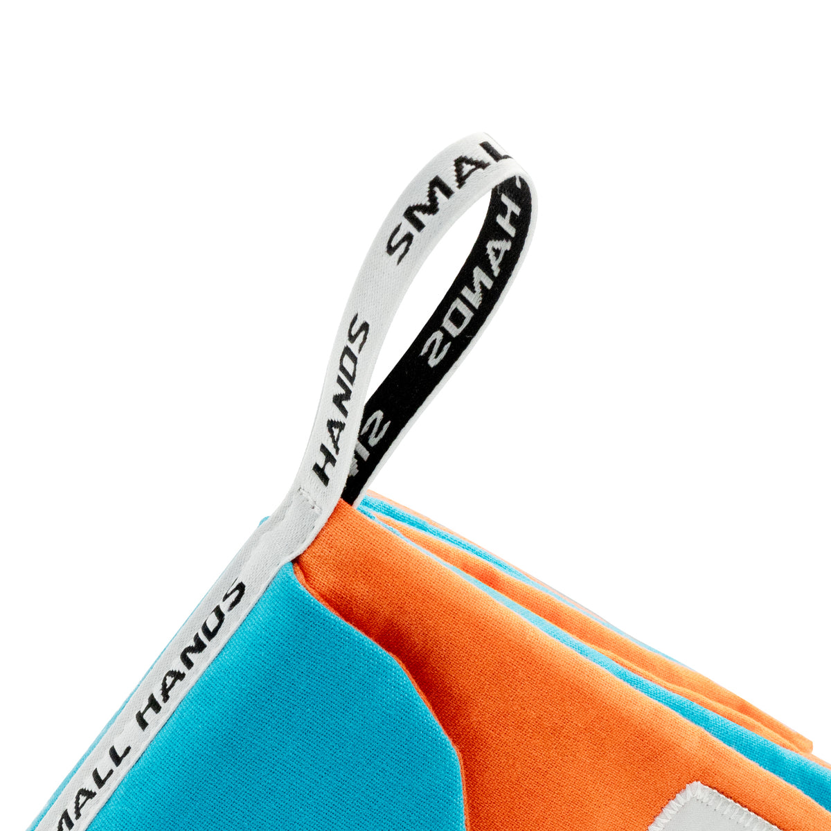 Mascotas libro de tela sensorial Montessori de Small Hands – primer plano de la cinta de tela estampada SMALL HANDS para colgar en la esquina naranja y azul del libro